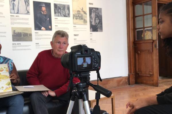 An image of an adult and a child sat in front of a camera.
