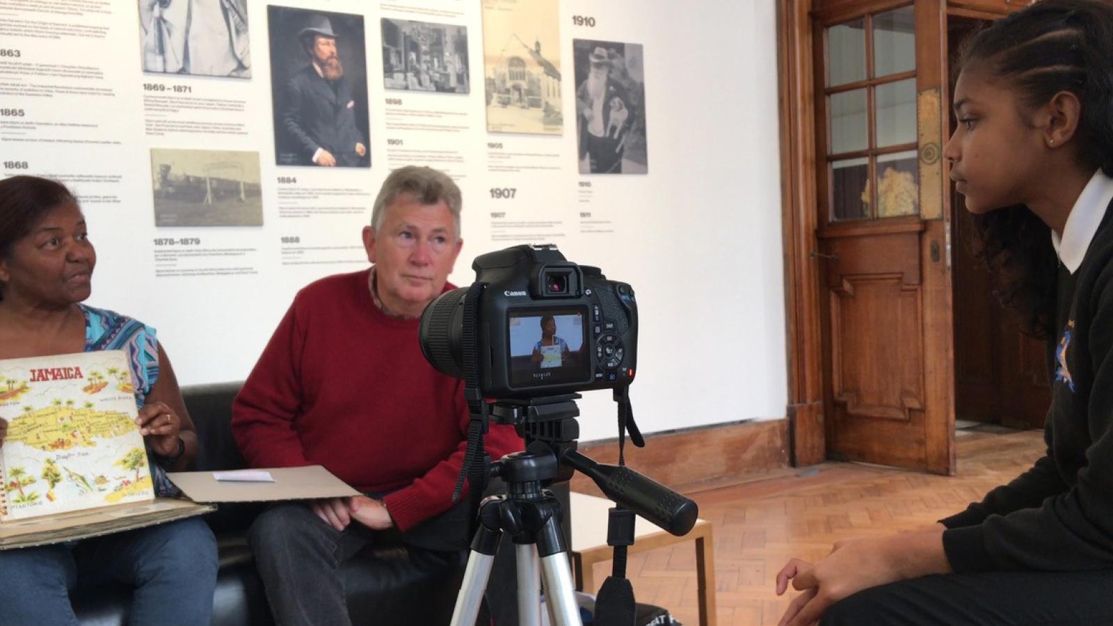 An image of an adult and a child sat in front of a camera.
