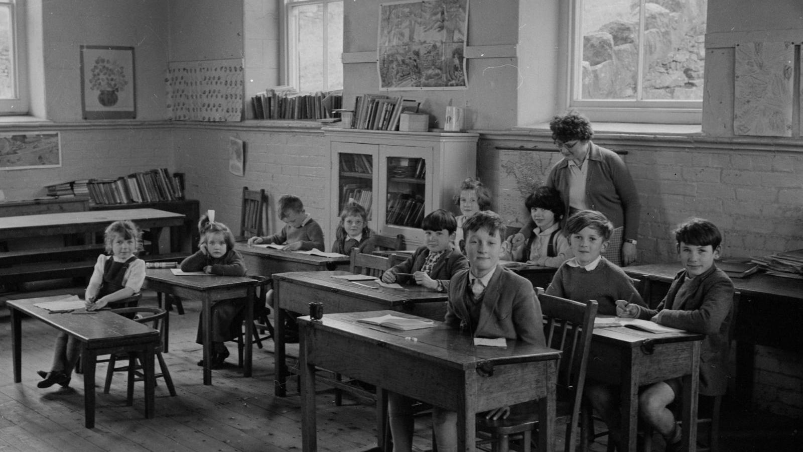 A black and white image of children in a classroom.